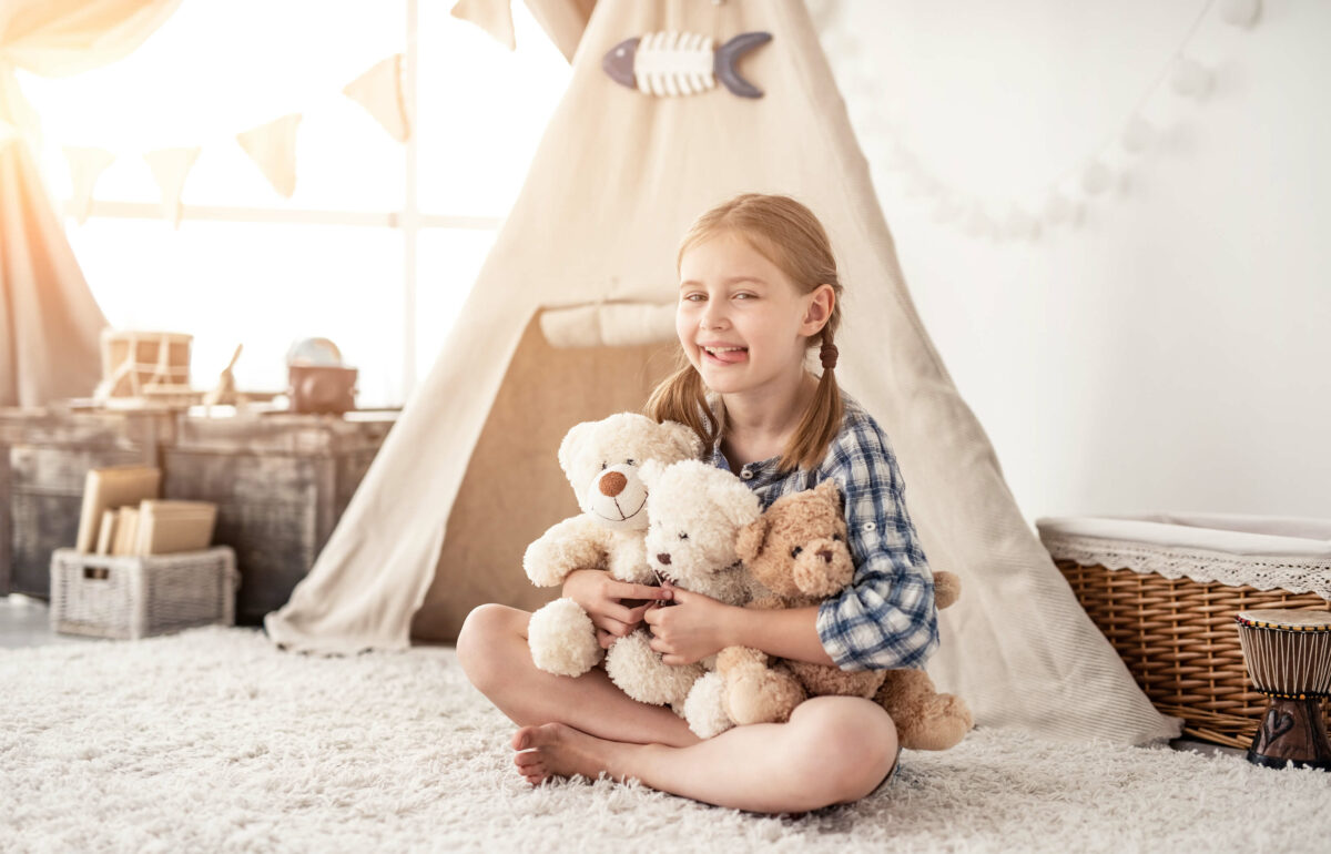 Ein Kind, Mädchen in Spieleckemit Teddys und Spielzelt